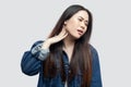 Neck pain. Portrait of sick beautiful brunette asian young woman in casual blue denim jacket standing feeling discomfort and Royalty Free Stock Photo