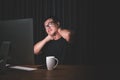 Neck pain or tired concept. Man touching his neck because pain or hurt after long time working on computer in the dark room at