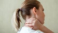 Neck shoulder pain, cervical vertebrae. Woman holds neck with pain cervical muscle spasm by hand at home. Healthcare