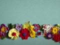 A necklace of colored crocheted flowers lies on the paper Royalty Free Stock Photo