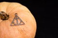 Necklace of deathly hallows on pumpkin with copy space for text