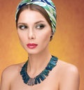 Necklace and hair with a headscarf. Beauty portrait of young beautiful woman