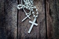 Necklace white crucifix on old wooden table