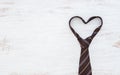 Necktie in heart shape on grunge white wooden table background. Top view with copy space. Father& x27;s day background concept
