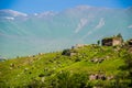 Necropolis on grassy slope, background mountains