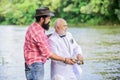 he need help. hobby and recreation. two fishermen with fishing reel. family, granddad and drandson fishing. retired Royalty Free Stock Photo