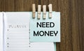 Need Money notes paper and a clothes pegs on wooden background Royalty Free Stock Photo