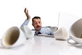 Portrait of young sleepy Caucasian man, office worker sitting at table on white background. Royalty Free Stock Photo