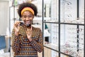 Need a new glasses. Young woman african american in optic store choosing a new eyeglasses frame. Medical, health care concept,