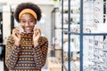 Need a new glasses. Young woman african american in optic store choosing a new eyeglasses frame. Medical, health care concept,