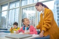 Smiling teacher praising schoolgirl for her efforts