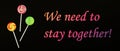 We need to stay together, motivational slogan in a difficult period of life, pandemic, lollipops on a black background