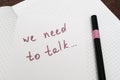 We need to talk message frase written on white piece of paper with a marker, communication problems in family or work