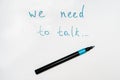 We need to talk message frase written on white piece of paper with a marker, communication problems in family or work