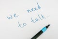 We need to talk message frase written on white piece of paper with a marker, communication problems in family or work