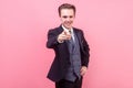 We need you! Portrait of positive successful elegant businessman in tuxedo pointing at camera. isolated on pink background Royalty Free Stock Photo