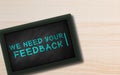 We need your feedback hand Written in Small chalkboard on Wooden background with Copy space. Blue Chalk. Customer feedback