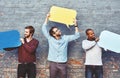 We needed to say something. a group of young men holding speech bubbles against a brick wall. Royalty Free Stock Photo