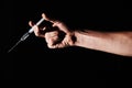 Needle, drugs in hand and person on black background with medicine, insulin or vaccine in studio for health Royalty Free Stock Photo