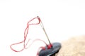 Needle eye with red thread , black button on hemp rope Royalty Free Stock Photo