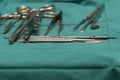Needle holders, surgical knifes, forceps on green table