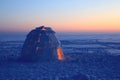 A snowy house called an igloo at sunset. Royalty Free Stock Photo