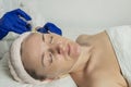 Needle mesotherapy in a beauty clinic. Cosmetics are injected into the woman`s face