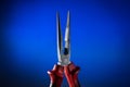 Needle Nose Pliers on the blue background Royalty Free Stock Photo