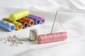 Needle, pins, thimble and colorful spools of thread Royalty Free Stock Photo