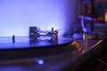 Needle playing vinilo record on a blue led light