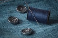 Needle and spool of thread on jeans fabric Royalty Free Stock Photo