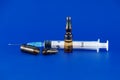 Close-up view of syringe and ampoule over blue Royalty Free Stock Photo