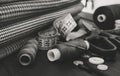 A needle with thread, buttons and scissors lie on a wooden background. Black and white photo Royalty Free Stock Photo