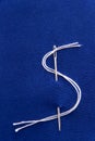 Needle and thread in dollar sign shape