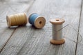 Needle and thread and vintage thread spools on wooden background, needlework, design and clothing repair concept