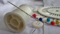 Needle on white thread reel and button Household clothes repair Royalty Free Stock Photo