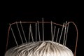 Needles and orange cotton thread on a white cotton tread ball macro closeup Royalty Free Stock Photo