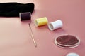 needles spools with threads and a torn sock on a pink background Royalty Free Stock Photo