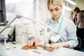 Needlewoman sews fabrics on a sewing machine