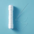 Needlework supplies Skein of white thread with needle, blue background