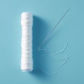 Needlework supplies Skein of white thread with needle, blue background Royalty Free Stock Photo