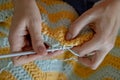 Needlework. Women`s hands close up crocheting children`s plaid. Crochet hook Royalty Free Stock Photo