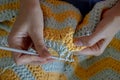 Needlework. Women`s hands close up crocheting children`s plaid. Crochet hook Royalty Free Stock Photo