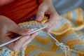 Needlework. Women`s hands close up crocheting children`s plaid. Crochet hook Royalty Free Stock Photo