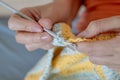 Needlework. Women`s hands close up crocheting children`s plaid. Crochet hook Royalty Free Stock Photo