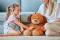 He needs a checkup. a little girl and her mother playing doctor with a teddybear at home. Royalty Free Stock Photo