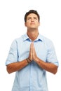 He needs divine intervention. A handsome young man with hands together in prayer against a white background. Royalty Free Stock Photo