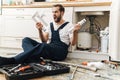 Negative emotional man plumber holding pipe Royalty Free Stock Photo