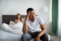 Negative emotions, problems, quarrel. Young black guy feeling upset, his wife yelling at him in bedroom