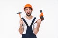 Negative thinking young man holding drill and hammer Royalty Free Stock Photo